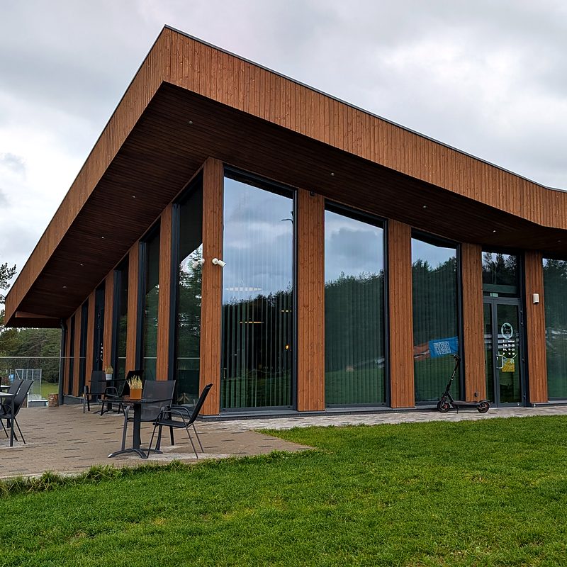 The Maitsete Maja glass pavilion in Keila by day: timber facade, tall windows and a terrace